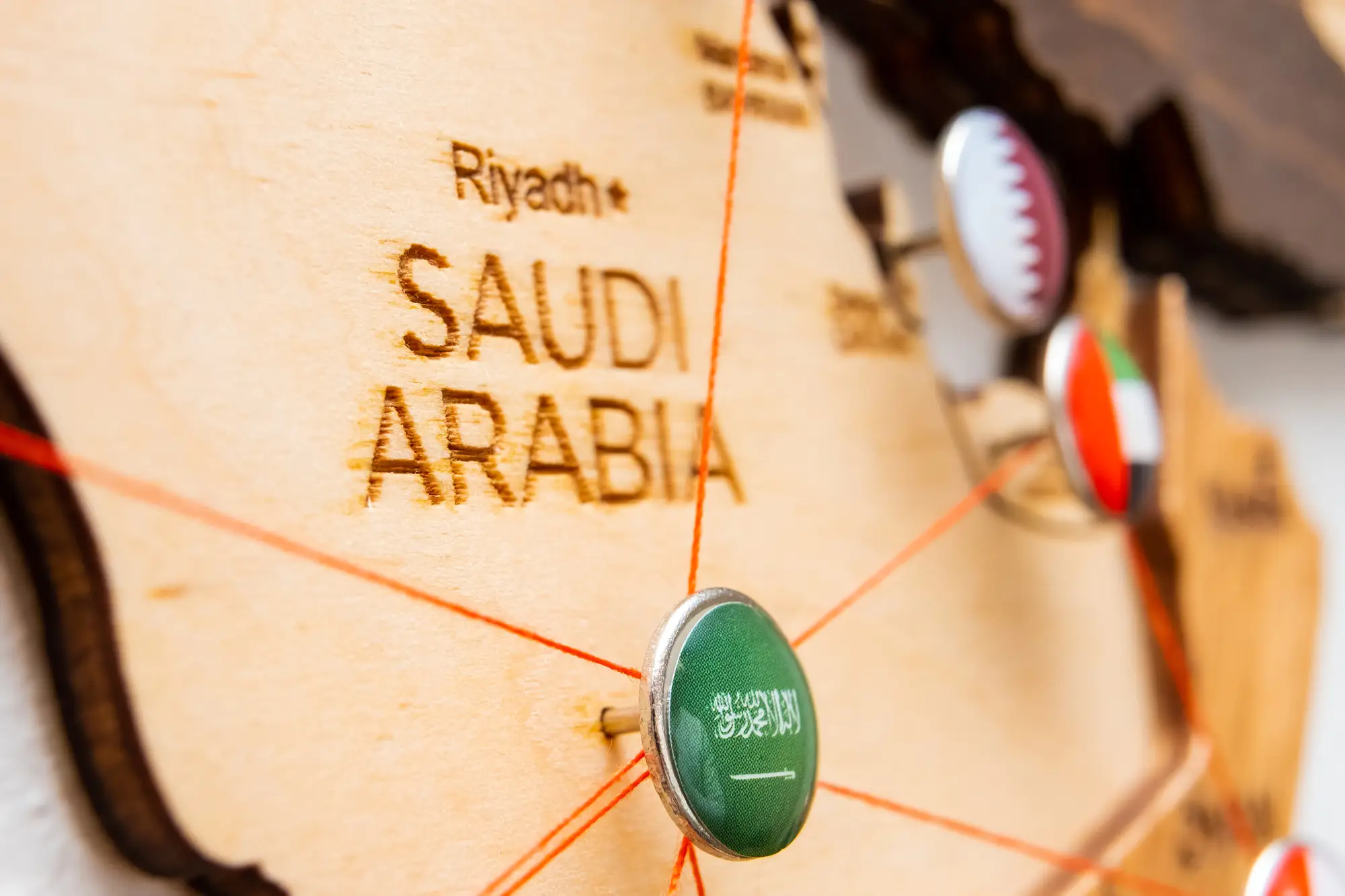 البرامج 14 Saudi Arabia flag on the pushpin and red threads on the wooden map