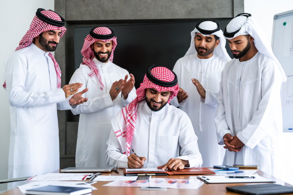 🎯 أهداف التخطيط الاستراتيجي: بوصلتك نحو النجاح المؤسسي 3 Arab businessmen wearing emirati and saudi kandura meeting in the office