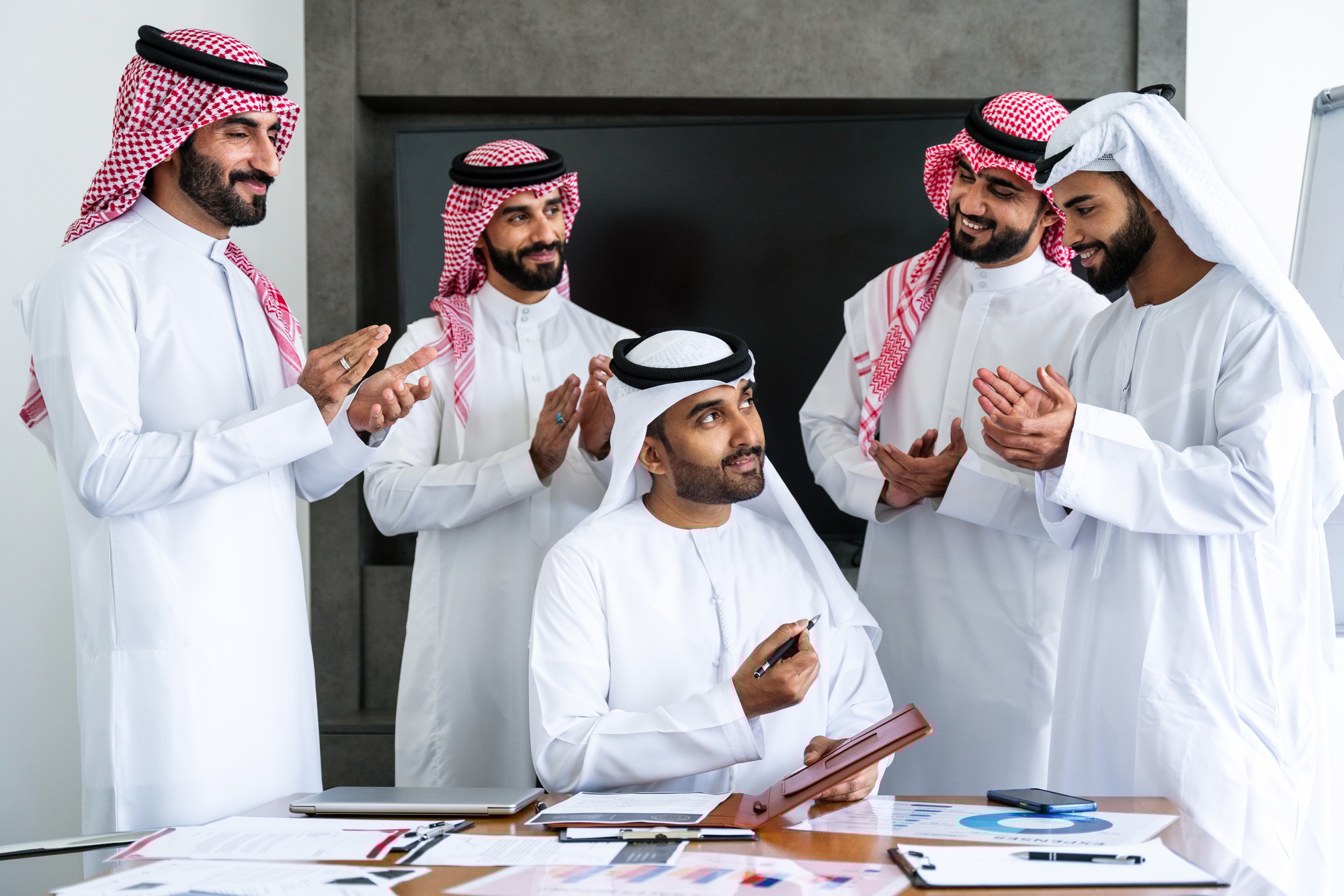 Arab businessmen wearing emirati and saudi kandura meeting in the office