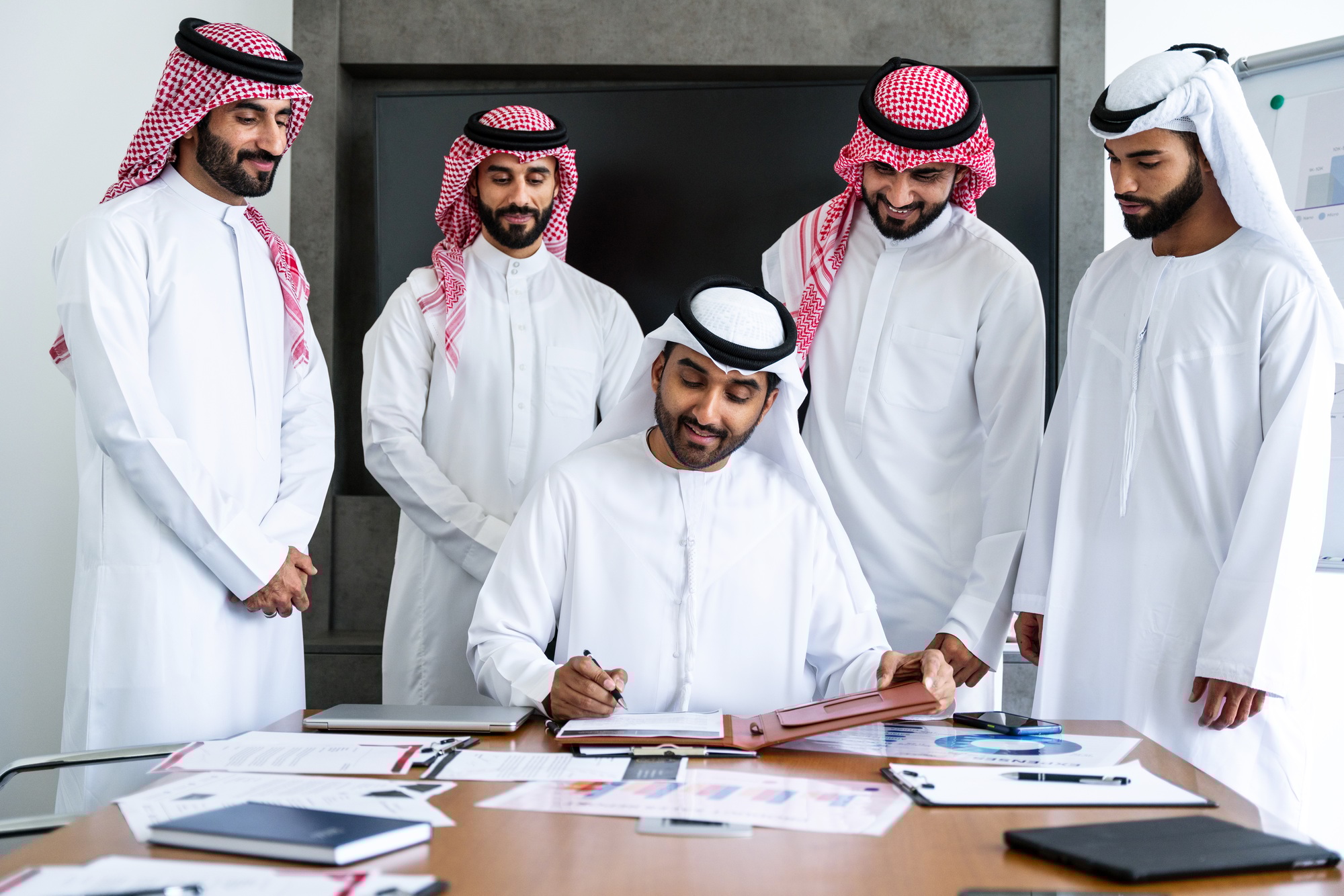 Arab businessmen wearing emirati and saudi kandura meeting in the office