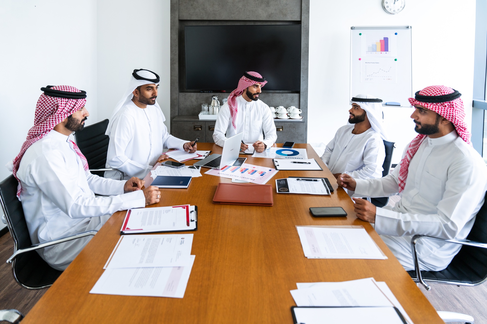 Arab businessmen wearing emirati and saudi kandura meeting in the office