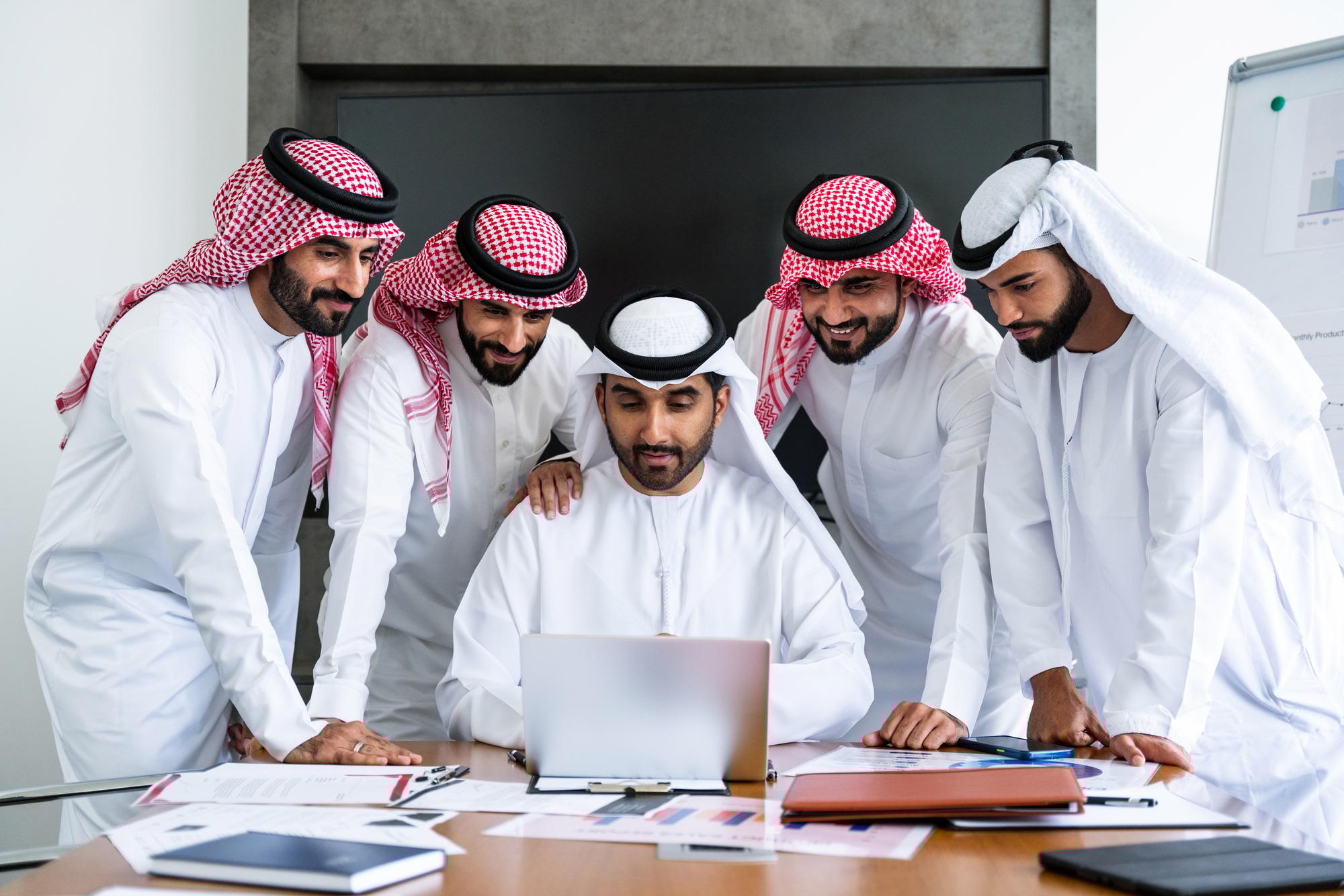 Arab businessmen wearing emirati and saudi kandura meeting in the office