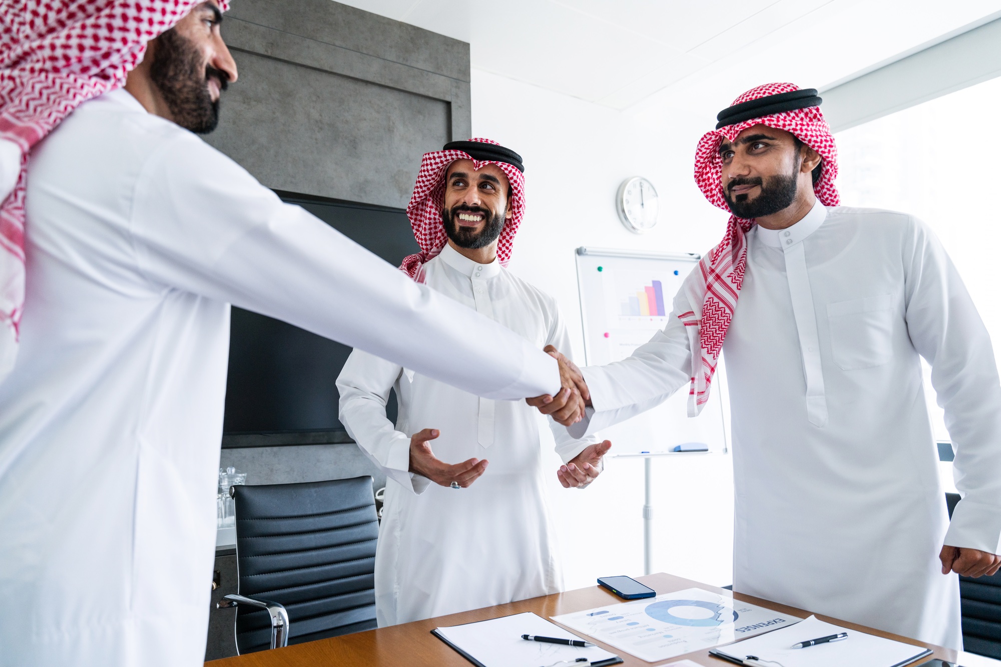 Arab businessmen wearing saudi kandura meeting in office for business deal