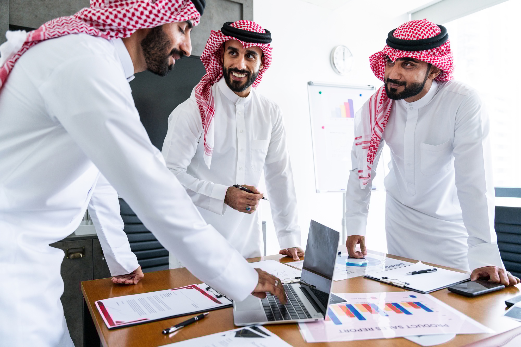 Arab businessmen wearing saudi kandura meeting in office for business deal