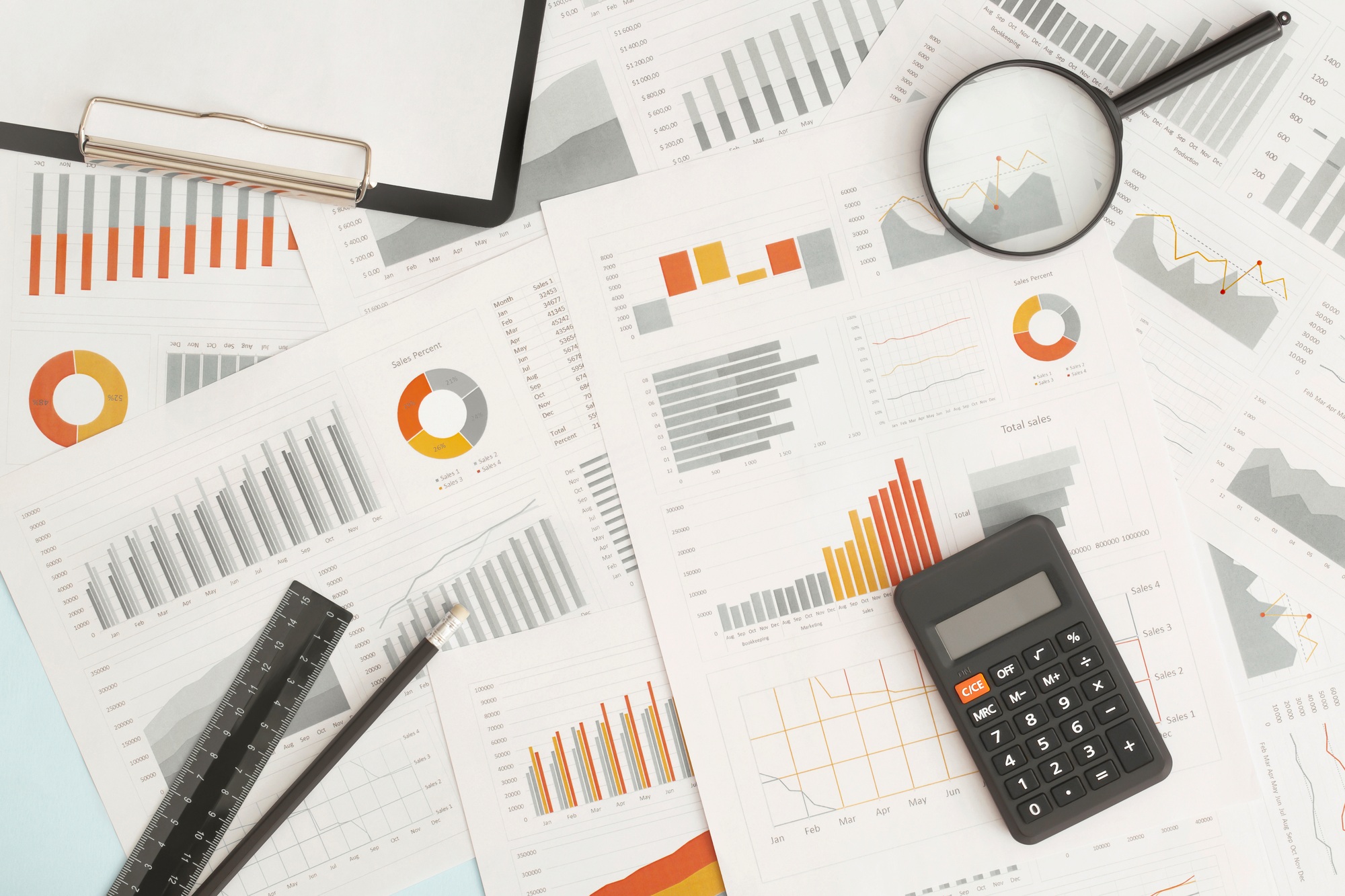 Business graphs, charts, magnifying glass and calculator on table. Financial development